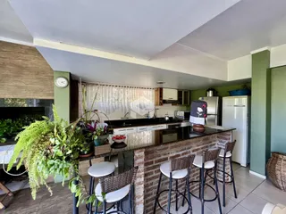 Cozinha com balcão de tijolos e bancos de madeira.