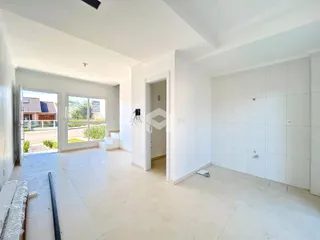 Ambiente interno de uma sala ampla com porta de vidro abrindo para o exterior.