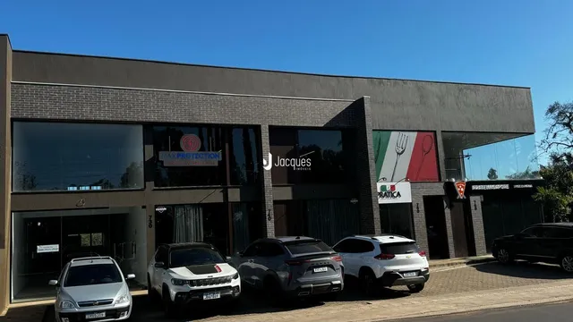 Fachada de um imóvel em Lajeado, Brasil, com grandes janelas e sinalização.