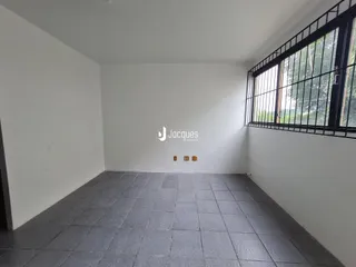 Ambiente interno de uma sala com paredes brancas e piso de cerâmica.