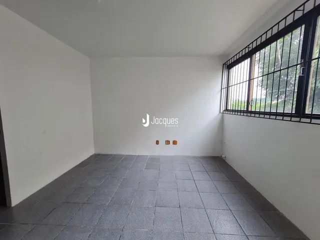 Ambiente interno de uma sala com paredes brancas e piso de cerâmica.