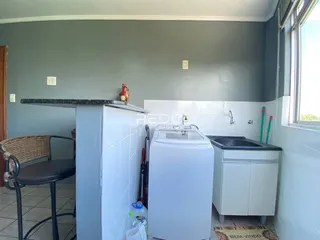 Interior de cozinha com área de serviço e banheiro em Lajeado.