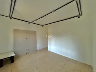 Imagem de um ambiente interno com piso de cerâmica e paredes brancas.