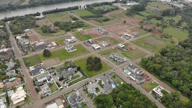 Vista aérea de um terreno com áreas verdes e estruturas dispersas em Lajeado, Brasil.
