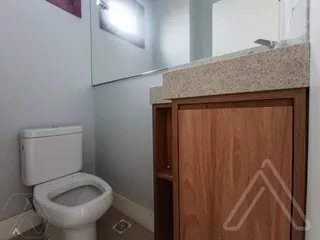 Foto de um banheiro mostrando um vaso sanitário e uma bancada de madeira.
