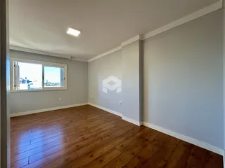 Sala de estar com piso de madeira e janela de vista para a cidade.