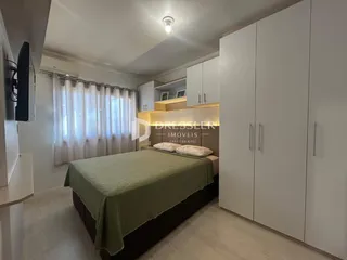 Quarto com cama e armários brancos em um imóvel no Brasil.