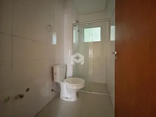 Foto de um banheiro com azulejos brancos e box de vidro.