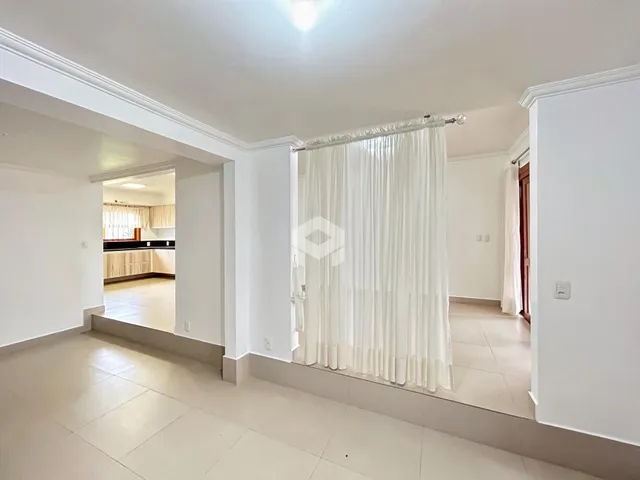 Ambiente interno de uma sala de estar com piso de cerâmica clara.