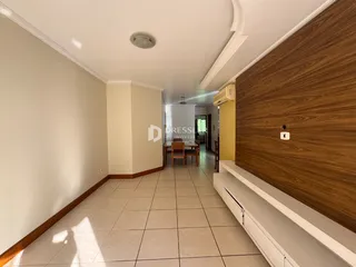 Corredor interno com piso cerâmico e paredes claras.