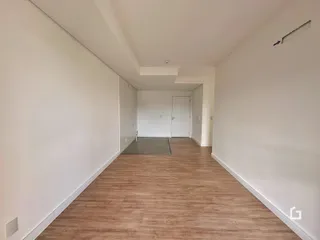 Hall de entrada com piso de madeira e paredes brancas.
