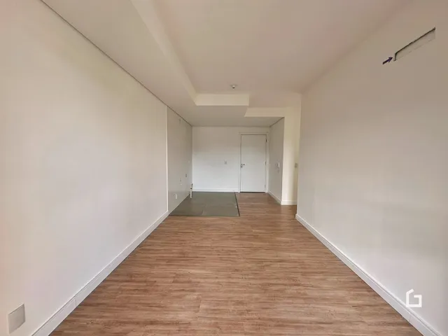 Hall de entrada com piso de madeira e paredes brancas.