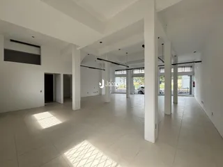 Vista interna de um espaço amplo com piso de cerâmica clara.