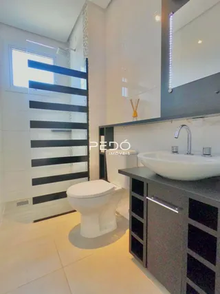 Interior de um banheiro moderno com revestimento branco.