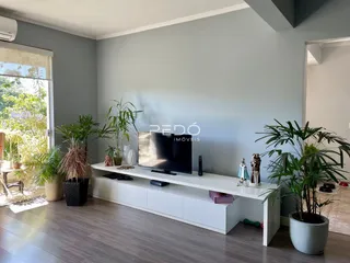 Sala de estar com piso de madeira e plantas decorativas.