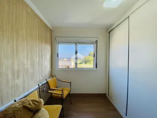Sala de estar com janela e poltrona amarela.