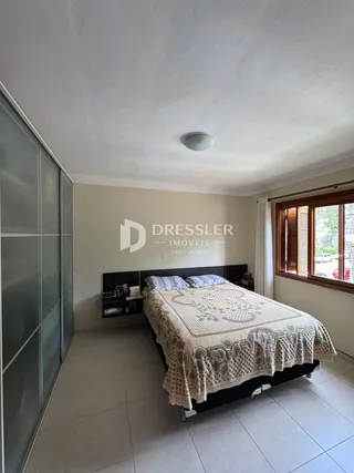 Quarto com cama e janela em uma residência.