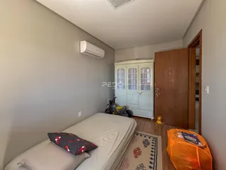 A foto mostra um quarto com cama e guarda-roupa em um imóvel.