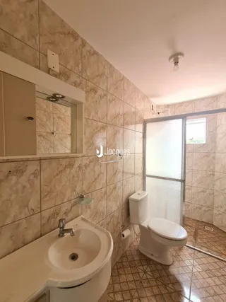 Foto de um banheiro com revestimento de cerâmica e vaso sanitário.