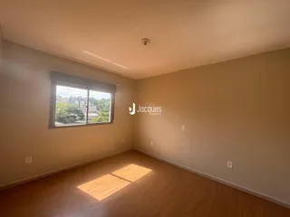 Sala de estar com piso de madeira e janela em um imóvel no Brasil.
