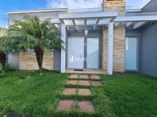 Fachada de uma residência em Lajeado, Brasil, com jardim e acesso à garagem.