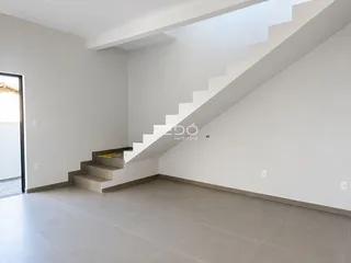 Vista de um ambiente interno com escadaria e piso de cerâmica.