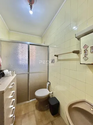 A foto mostra o interior de um banheiro com azulejos brancos.