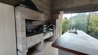 Foto de uma cozinha com estrutura de alvenaria aparente e bancada de pedra.