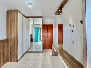Hall de entrada com revestimento de madeira e piso cerâmico.