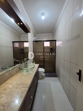 Banheiro com bancada de granito e azulejos brancos