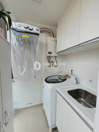 Cozinha moderna com armários brancos e pia de aço inoxidável.