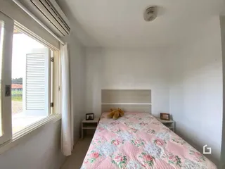 Quarto com janela e cortinas brancas.