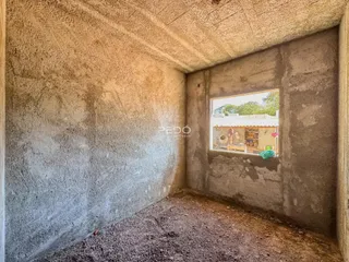 Foto de um cômodo interno com paredes de concreto bruto.