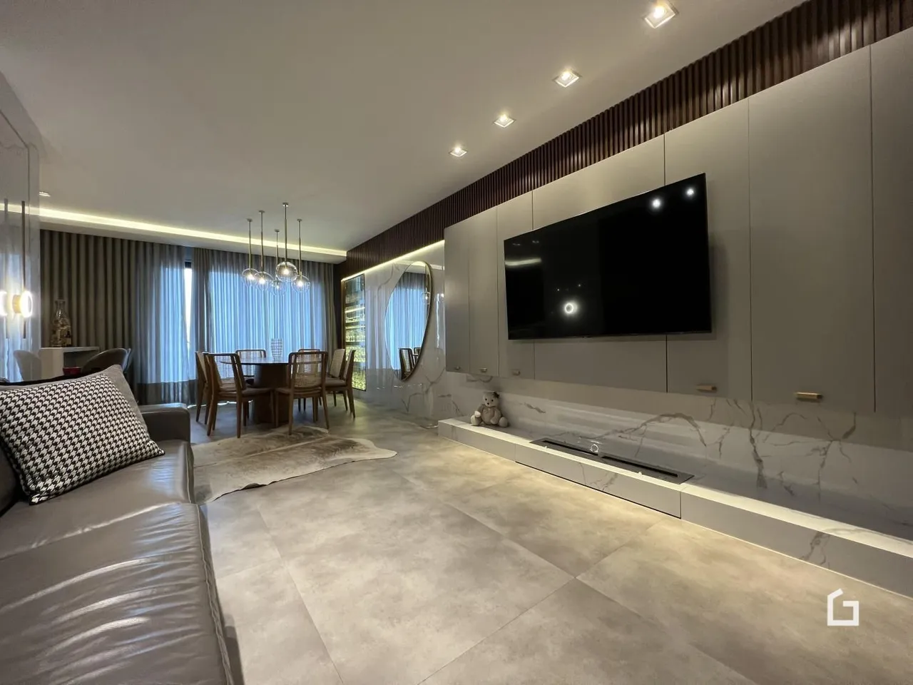 Sala de estar moderna com piso de porcelanato e móveis planejados.