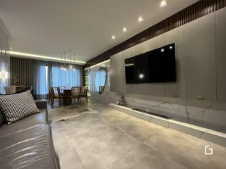 Sala de estar moderna com piso de porcelanato e móveis planejados.