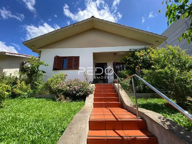 Fachada de uma casa em Lajeado, Brasil com jardim e escadaria externa.