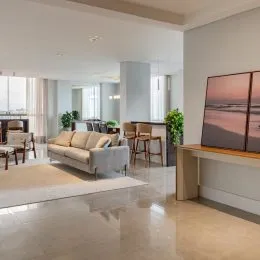 Foto de uma sala de estar ampla com sofá e piso claro.