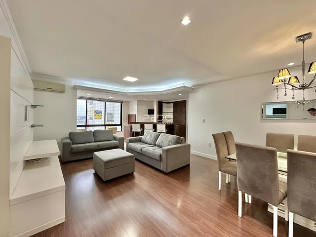 Sala de estar com piso de madeira e sofás modernos.