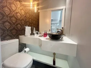 Foto de um banheiro com vaso sanitário e pia brancos.