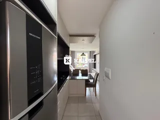 Vista de uma cozinha com eletrodomésticos de aço inoxidável e piso de cerâmica.