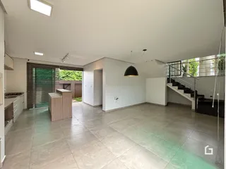 Interior de uma sala de estar com piso de cerâmica e porta de vidro abrindo para o exterior.