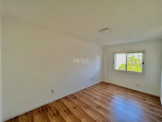Ambiente interno com piso de madeira clara e paredes brancas.