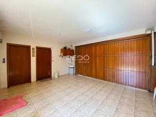 Foto de uma sala com piso de cerâmica e portas de madeira em uma residência.