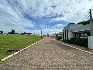 Caminho pavimentado em frente à propriedade com área gramada.