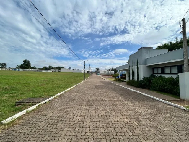 Caminho pavimentado em frente à propriedade com área gramada.