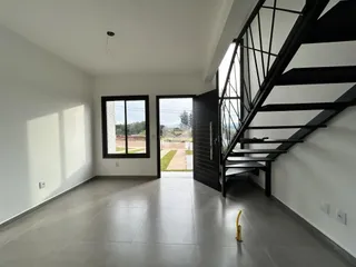 Interior de uma sala com piso de cerâmica e escadaria moderna.