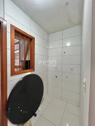 Corredor interno com paredes brancas e piso de cerâmica.