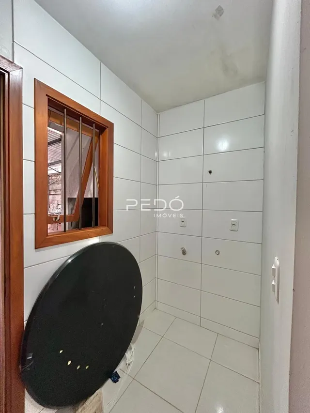 Corredor interno com paredes brancas e piso de cerâmica.