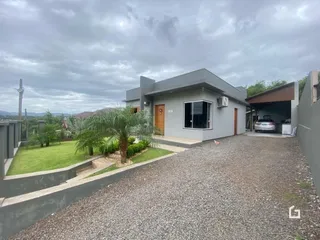 Fachada de uma casa moderna em Lajeado, Brasil, com jardim e entrada de cascalho.