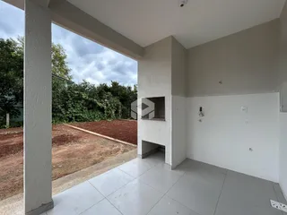 Vista de uma área comum com coluna e piso de cerâmica em uma residência.